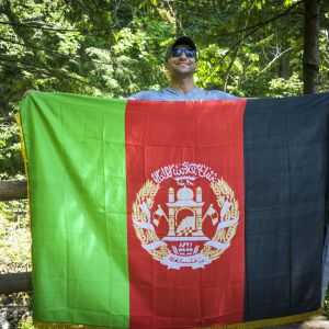Qais Qais, a former soldier from Afghanistan who had worked with the U.S. military, is now a refugee. During a summer hike with friends in the Columbia River Gorge, he proudly pulled the flag of his country from a backpack and posed for this triumphant photo.