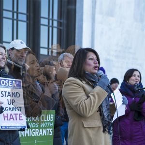Teresa Alonso Leon, the first Latina elected to the Oregon Legislature, speaks at a 2017 immigration rights rally in Salem, Oregon. The archival image is of Dolores Huerta, who — along with Cesar Chavez — co-founded the National Farm Workers Association, which later became the United Farm Workers union.